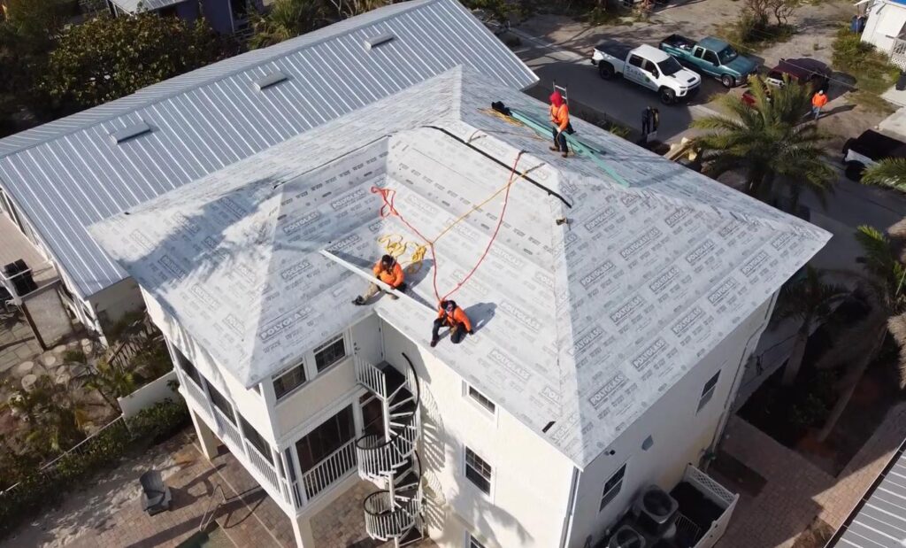 roofers installing a new roof with Polyglass underlayment on a multi-story house