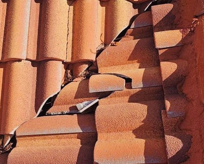 Damaged red clay tiles on a roof