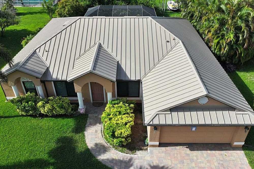 An aerial view of a suburban house with a beige metal roof.