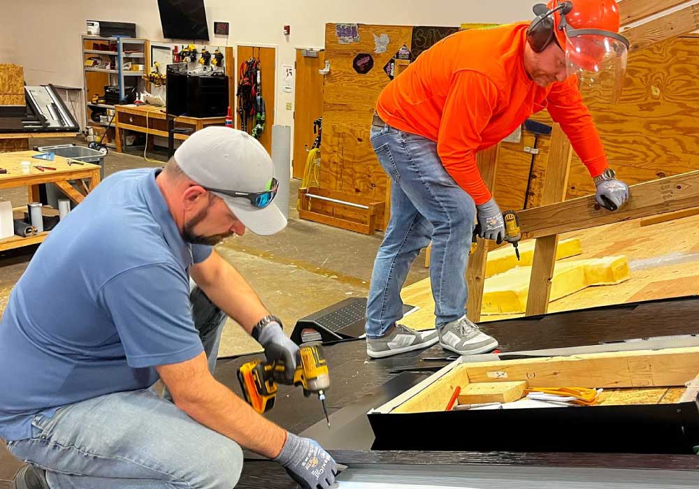 workers install materials on a workshop's roof structure