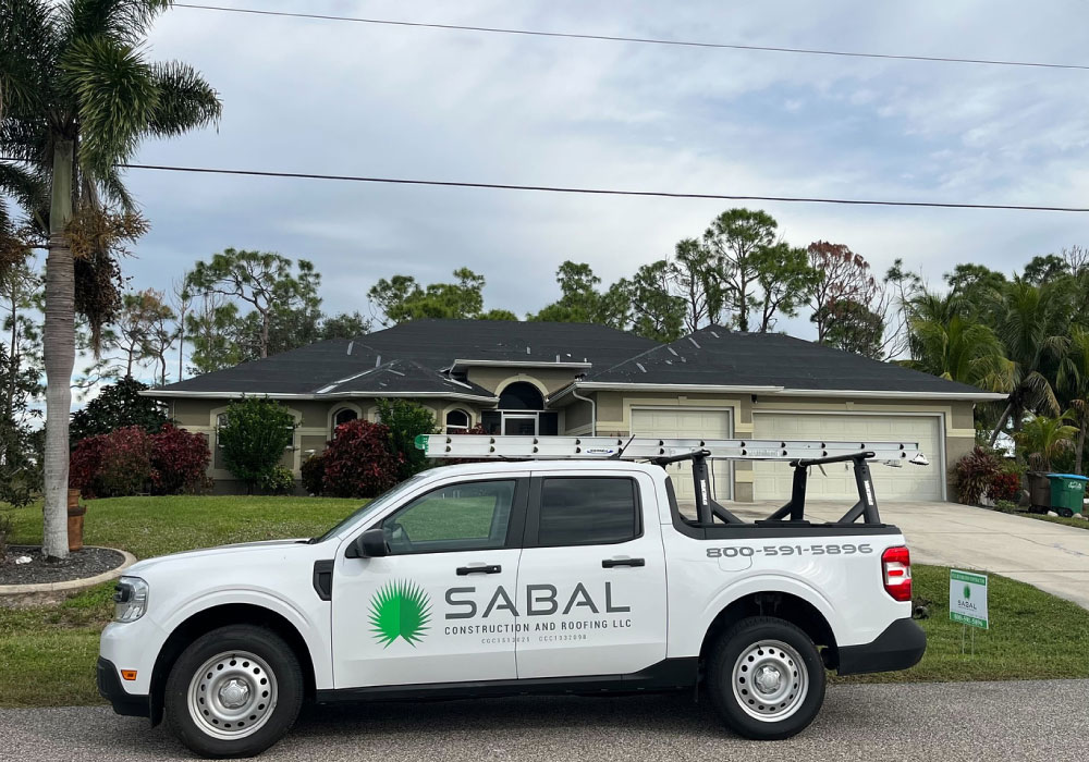 A Sabal Construction and Roofing truck is parked in front of a house.
